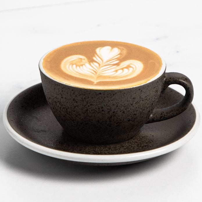 Classic Coffee_Flat White A flat white in a charcoal grey cup on a marbled white background.